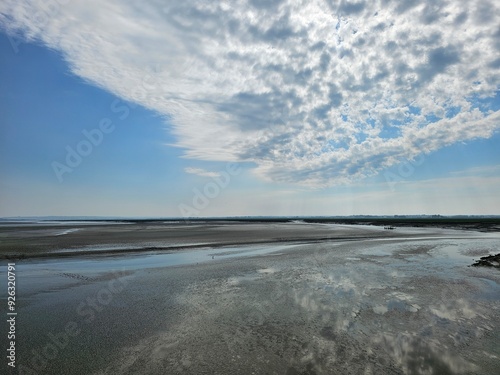 Mont Saint Michel, France - May 20, 2024: Beautiful landscape from Mont Saint Michel Normandy France in spring. Sky colours reflected over the water. Green land with first sunny days.