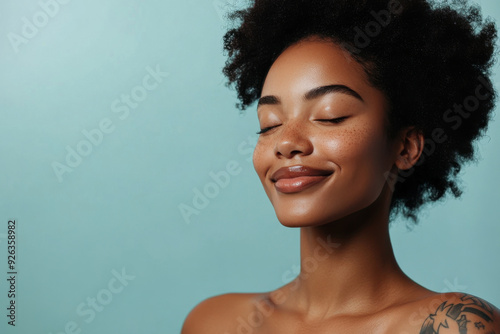 A close up of a tattooed black woman's face with her eyes closed