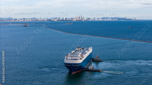Fotografie tug boat pulling ro ro ship in the ocean