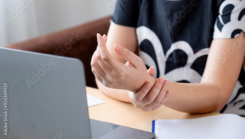 A successful business woman sitting in the office Using a laptop to work so hard that it hurts her wrists