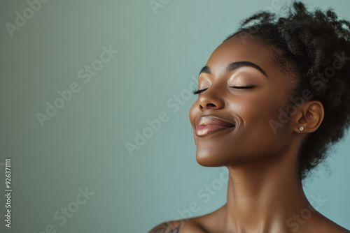 A close up of a tattooed black woman's face with her eyes closed