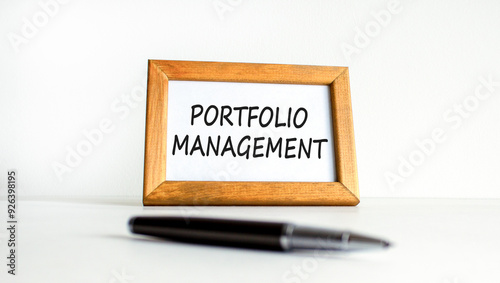 Portfolio management symbol. Concept words Portfolio management on beautiful wooden picture frame. Beautiful white paper background. Black pen. Business Portfolio management concept. Copy space.