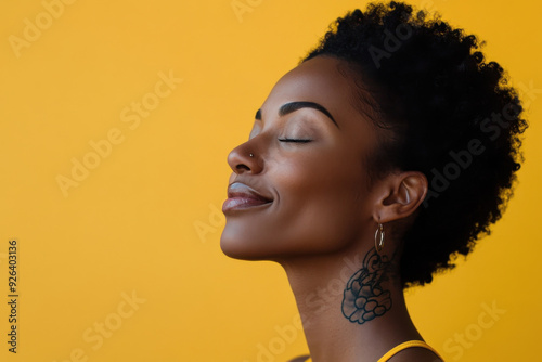 A close up of a tattooed black woman's face with her eyes closed