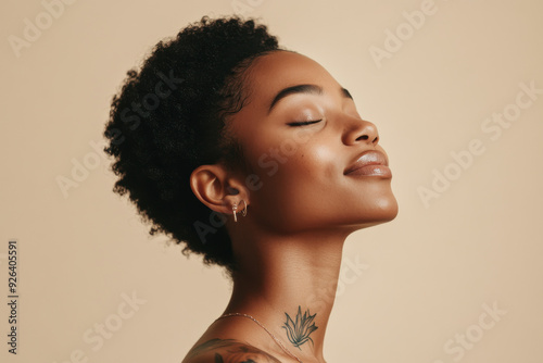 A close up of a tattooed black woman's face with her eyes closed