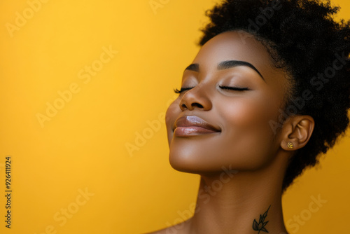 A close up of a tattooed black woman's face with her eyes closed