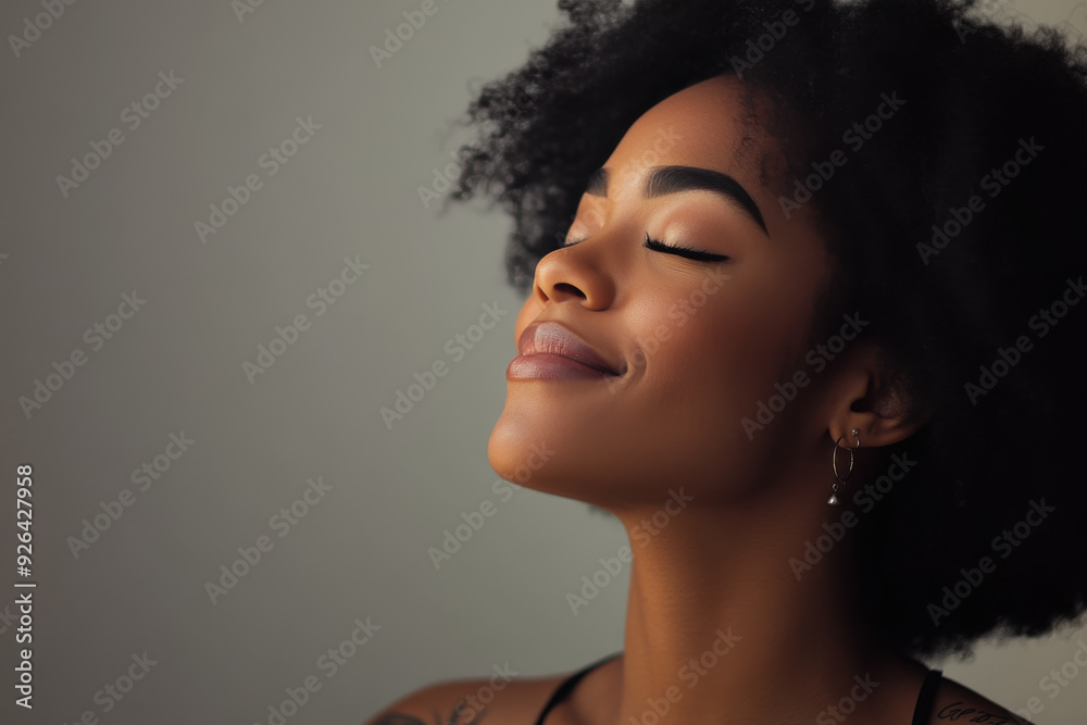 A close up of a tattooed black woman's face with her eyes closed