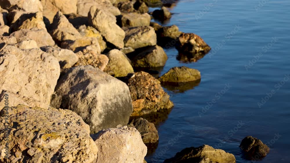 Mediterranean sea water moving next to rocks at sunrise, relaxing moment outdoors with nature Mediterranean sea water moving next to rocks at sunrise, relaxing moment outdoors with nature