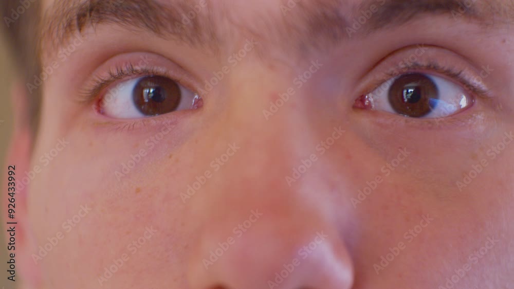 A surprised teenager looks at the camera with big bulging eyes. Eyes of a surprised or frightened person. Face of a modern person. Close-up. Shallow depth of field. A surprised teenager looks at the camera with big bulging eyes. Eyes of a surprised or frightened person. Face of a modern person. Close-up. Shallow depth of field.