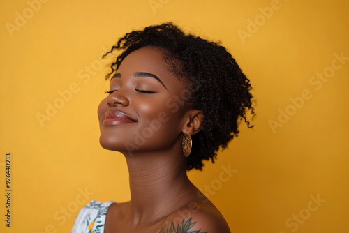 A close up of a tattooed black woman's face with her eyes closed