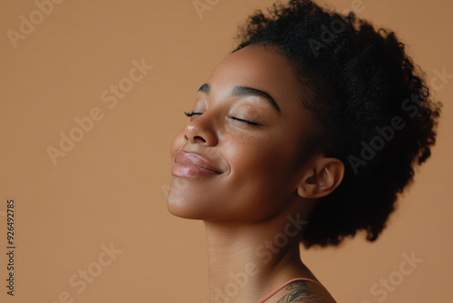 A close up of a tattooed black woman's face with her eyes closed