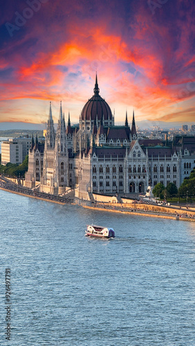 Stunning photo capturing the Hungarian Parliament building in Budapest during the blue hour, with amazing beautiful skies and the Danube River  with  a boat gracefully passing by