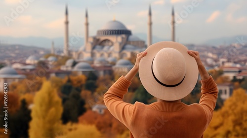 A traveler enjoys a stunning view of a historic mosque amidst autumn colors, capturing a moment of cultural exploration. photo