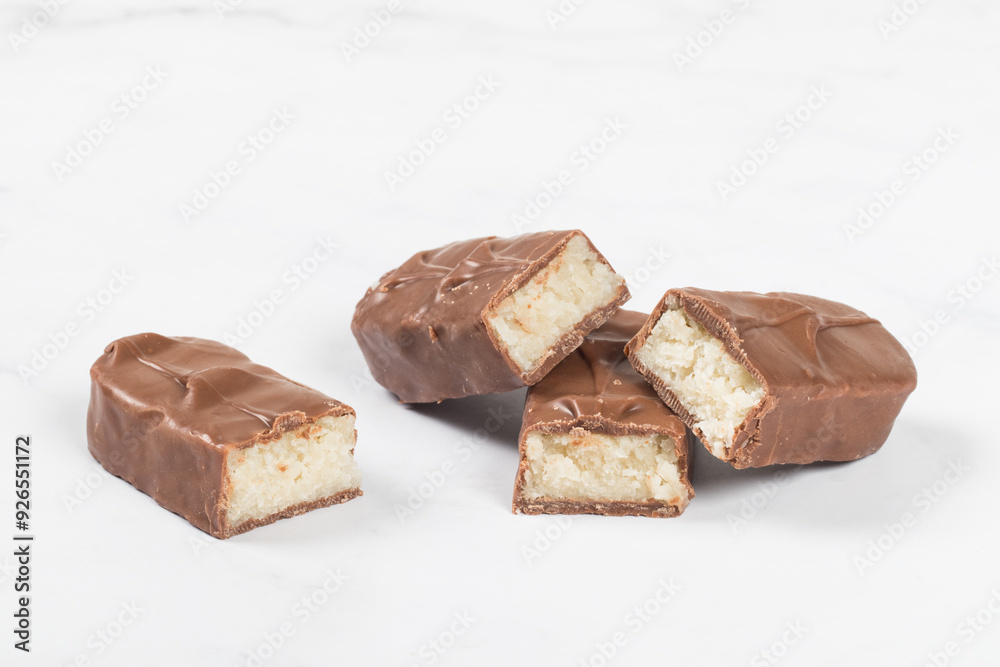 Candy bar with coconut pulp, in milk chocolate. Dark background. White background Candy bar with coconut pulp, in milk chocolate. Dark background. White background