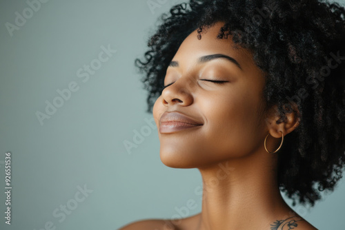 A close up of a tattooed black woman's face with her eyes closed