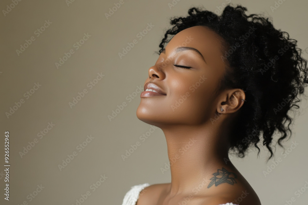 A close up of a tattooed black woman's face with her eyes closed