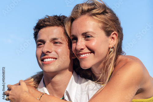 Happy couple in love embracing on the seashore. A man and a woman sitting on the sand near the ocean. Vows and promises by the sea.