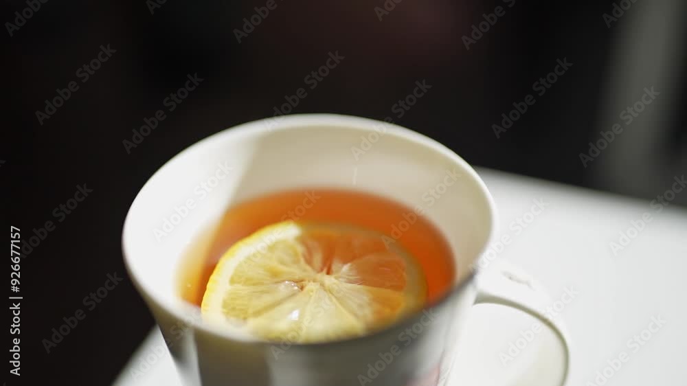 A steaming cup of refreshing lemon tea beautifully placed on a cozy, inviting table setting A steaming cup of refreshing lemon tea beautifully placed on a cozy, inviting table setting