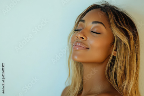 A close up of a black woman's face with her eyes closed and long blond hair