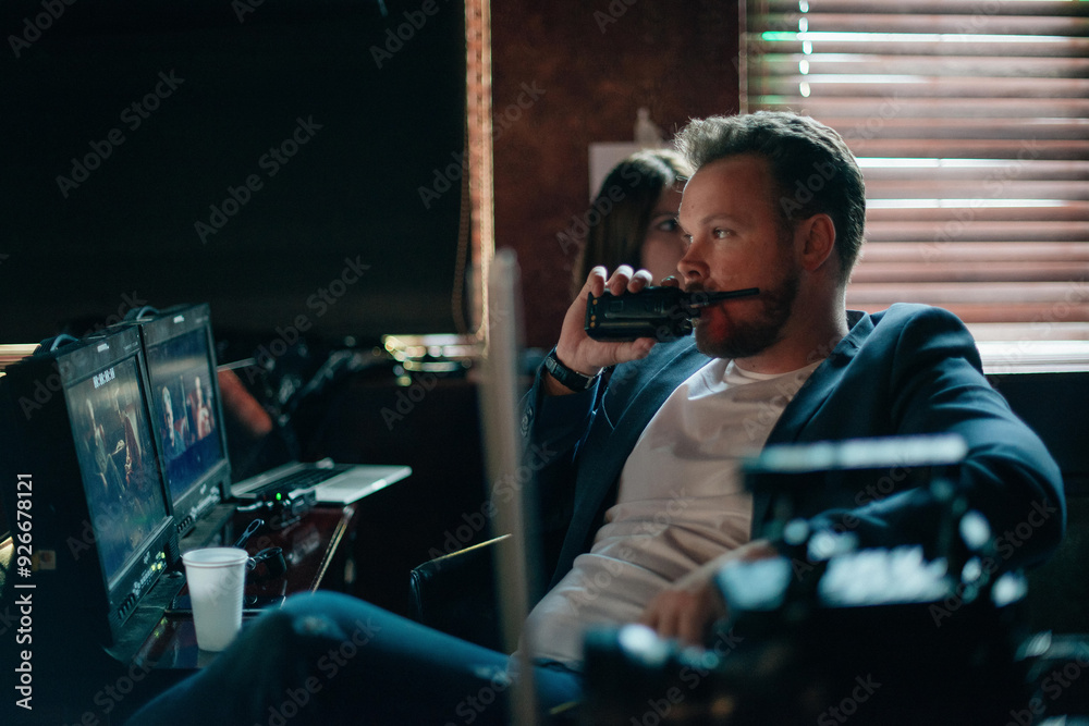 Director at work on the set. The director works with a group or with a playback while filming a movie, advertising, or a TV series. Director at work on the set. The director works with a group or with a playback while filming a movie, advertising, or a TV series.