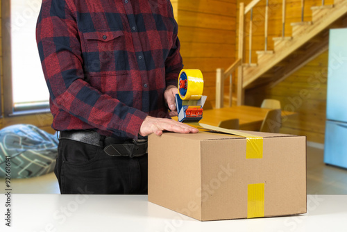 Man packs moving box. Guy s...