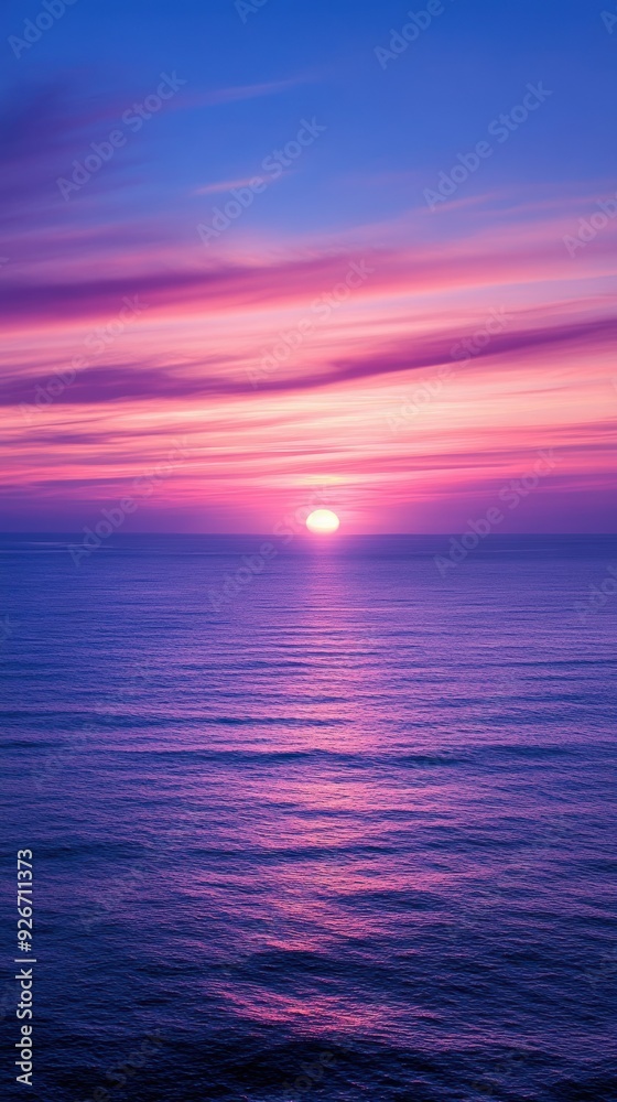 Fototapeta premium Serene ocean sunset with a pink and purple sky reflecting over calm waters. The soothing colors create a peaceful and tranquil atmosphere.