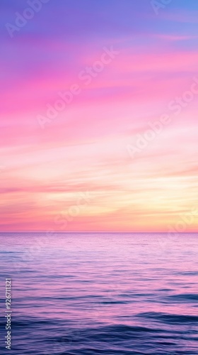Soft pastel sunset over the calm ocean, with gentle hues of pink, purple, and blue blending in the sky. The tranquil scene captures the serene beauty of nature.