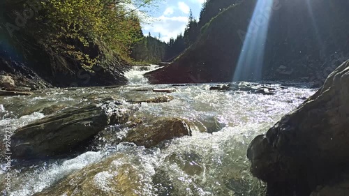 Splattering mountainous river on the background of beautiful mountains. Landscape with a fast mountain river. Mountainous rapid river. Idyllic landscape

