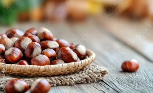 Fresh chestnuts in a woven basket with autumn leaves on a wooden table outdoors