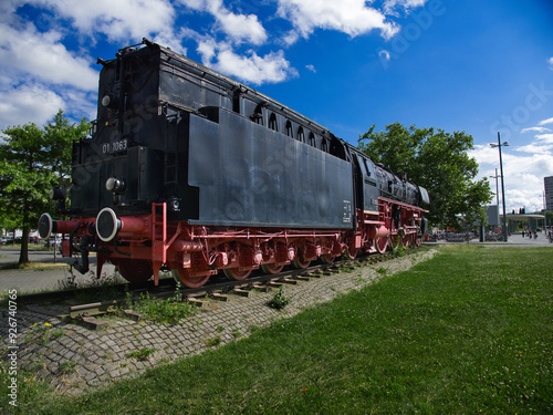 old steam locomotive, which is black and red and stands at the main station in Braunschweig as a museum piece
