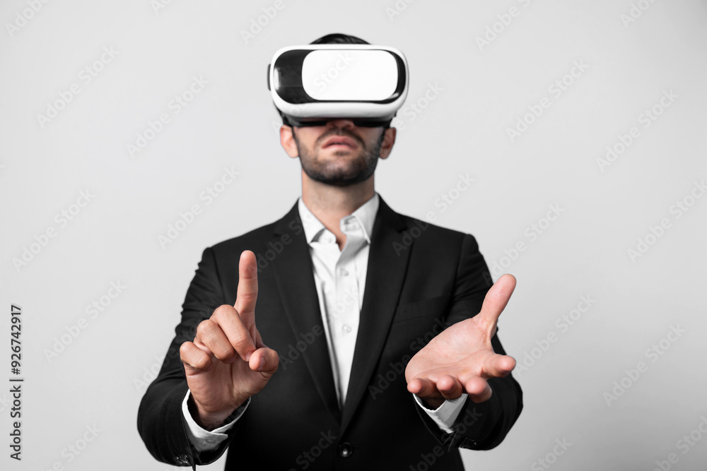 Smart businessman wears VR glasses and standing at white background while holding and pointing at something. Skilled project manager checking data analysis in metaverse or virtual reality. Deviation. Smart businessman wears VR glasses and standing at white background while holding and pointing at something. Skilled project manager checking data analysis in metaverse or virtual reality. Deviation.