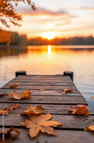 Autumn sunset view from wooden dock by serene lake with fallen leaves