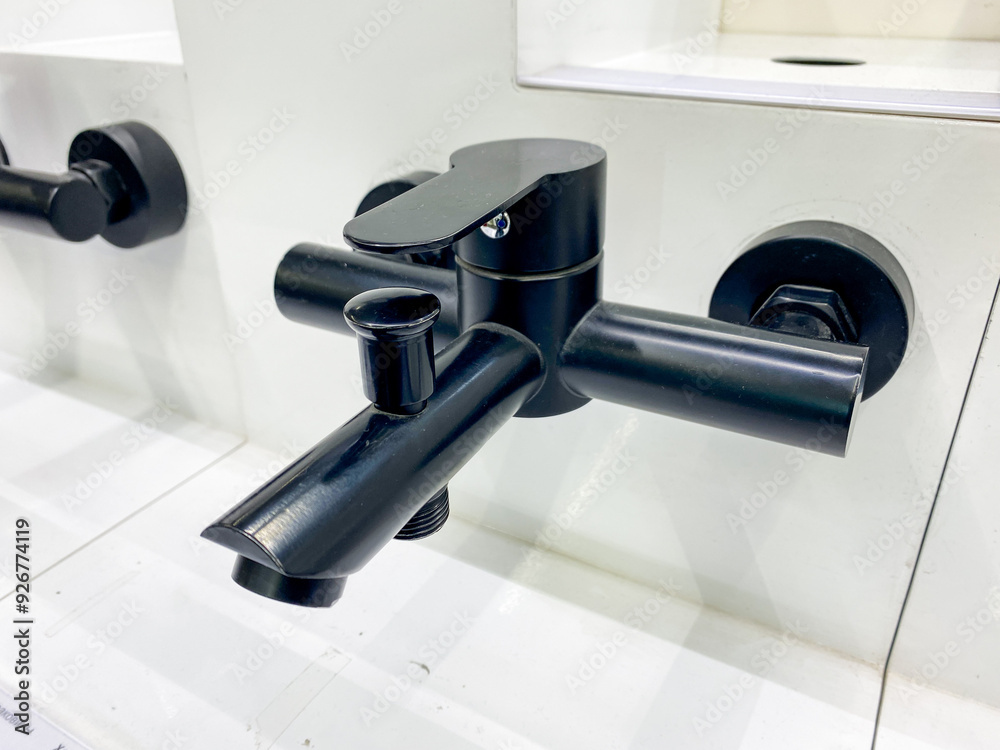 A sleek black bathtub faucet is elegantly sitting on top of a pristine white counter, creating a beautiful contrast that is both stylish and functional, adding a touch of modernity to the bathroom A sleek black bathtub faucet is elegantly sitting on top of a pristine white counter, creating a beautiful contrast that is both stylish and functional, adding a touch of modernity to the bathroom