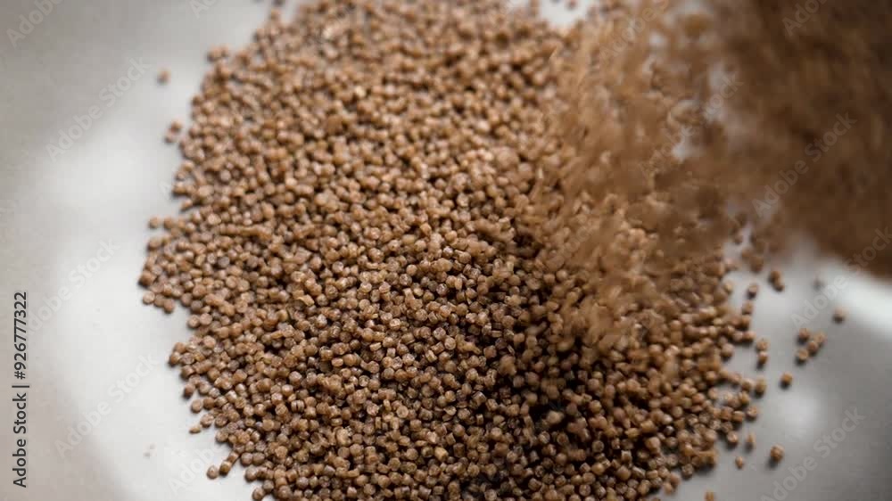 Preparation of dry buckwheat couscous. Pouring nutritious raw ingredient into a gray kitchen bowl for steaming close up Preparation of dry buckwheat couscous. Pouring nutritious raw ingredient into a gray kitchen bowl for steaming close up