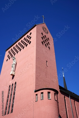 Kirchturmuhr im Spitzgiebel des Kichturm der katholischen Kirche St. Josef vor blauem Himmel im Sonnenschein in der Berger Straße im Stadtteil Bornheim in Frankfurt am Main in Hessen photo