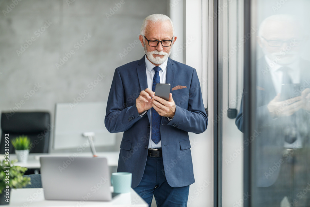 Senior Businessman Using Smartphone in Modern Office Senior Businessman Using Smartphone in Modern Office