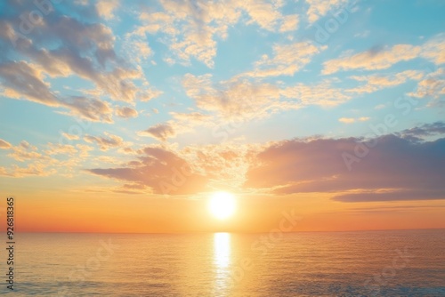 Serene summer sunset over the sea with golden sunlight reflecting on the water and soft clouds in the sky, creating a peaceful and tranquil atmosphere.