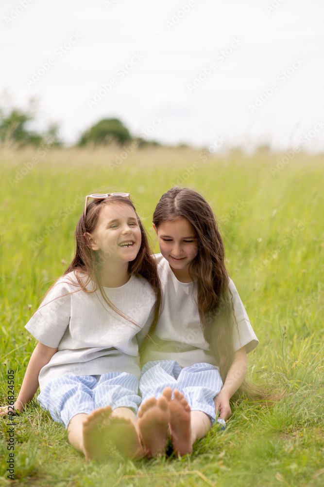 Fototapeta premium two sisters sitting on the grass