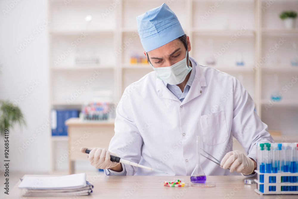 Young male chemist working at the lab Young male chemist working at the lab