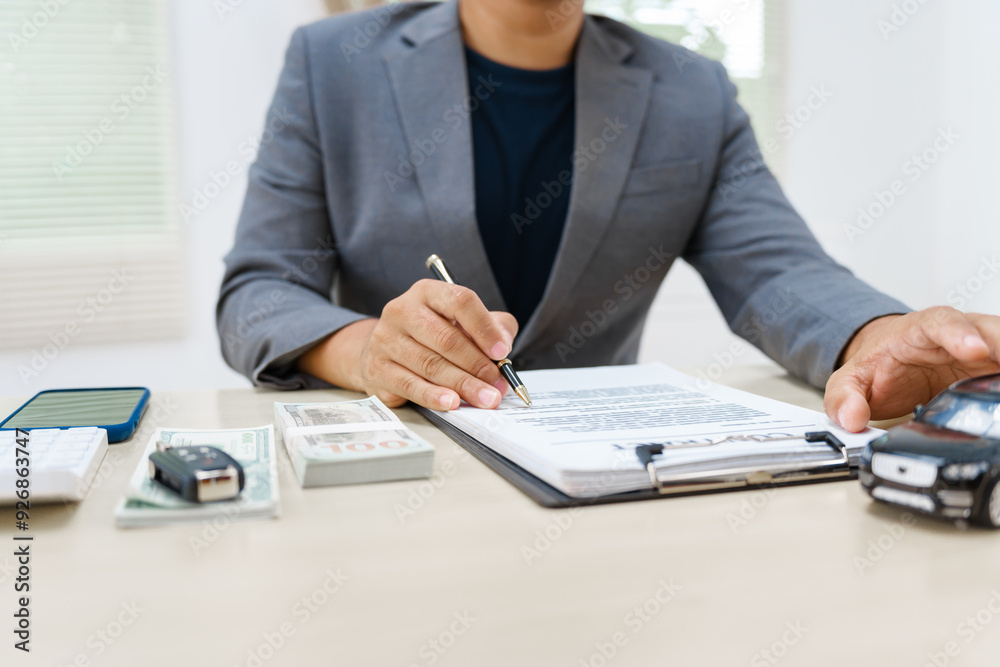 Asian business professional in a formal suit works at a desk, reviewing financial charts. manage car insurance claims, analyze auto loan options, sign lease agreements for vehicle transactions. Asian business professional in a formal suit works at a desk, reviewing financial charts. manage car insurance claims, analyze auto loan options, sign lease agreements for vehicle transactions.