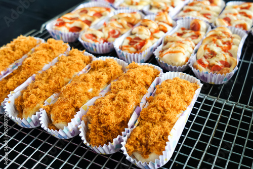 Slika na platnu Chicken floss bun and sausage swirl roll on cooling rack