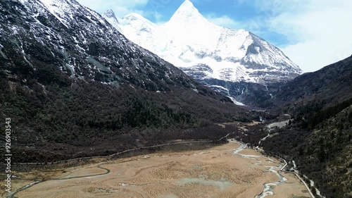 Drone shot of the scenic and breathtaking Yading nature reserve luorong pasture with Mount Yangmaiyong in background, located in Garze Tibetan Autonomous Prefecture, Sichuan, China