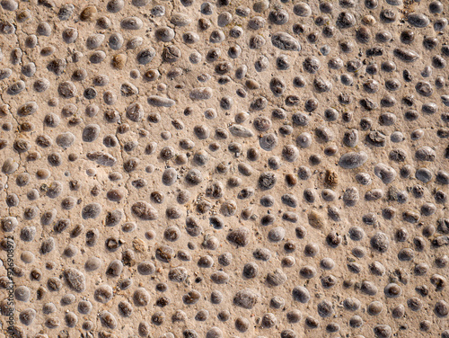 Pavement of river stone and concrete background. Abstract background with round pebbles stones. photo