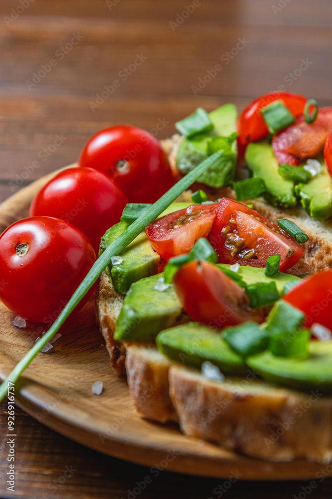 Avocado toast topped with tomato and green onion on a slice of carrot bread Avocado toast topped with tomato and green onion on a slice of carrot bread