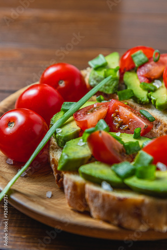 Avocado toast topped with tomato and green onion on a slice of carrot bread