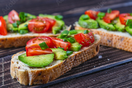 Avocado toast topped with tomato and green onion on a slice of carrot bread