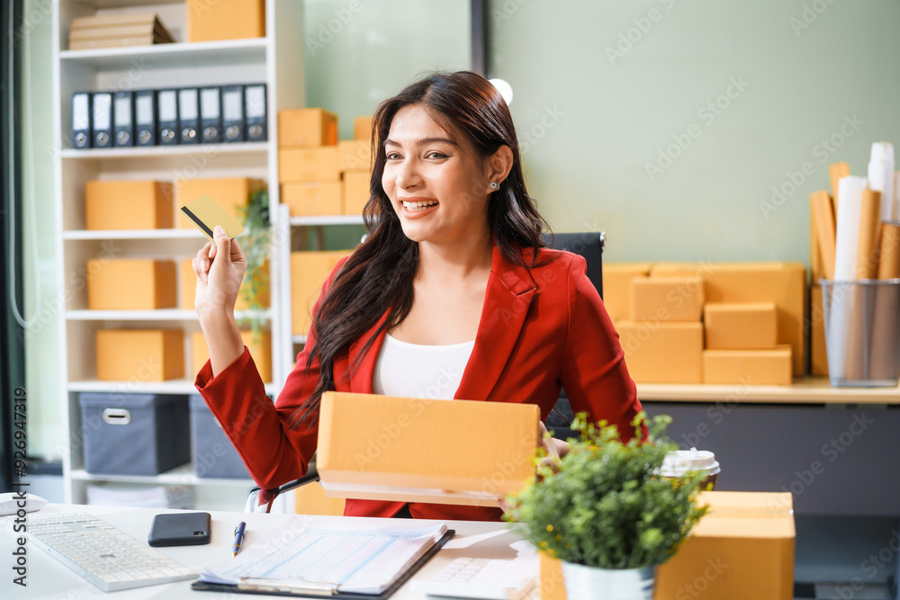 A beautiful businesswoman sits at the table, looking at the computer screen and talking on the phone. She analyzes marketing plans with a smile, feeling happy and successful in her online business. A beautiful businesswoman sits at the table, looking at the computer screen and talking on the phone. She analyzes marketing plans with a smile, feeling happy and successful in her online business.