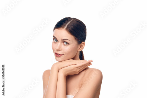 Young woman with hands on face posing beautifully against a white background