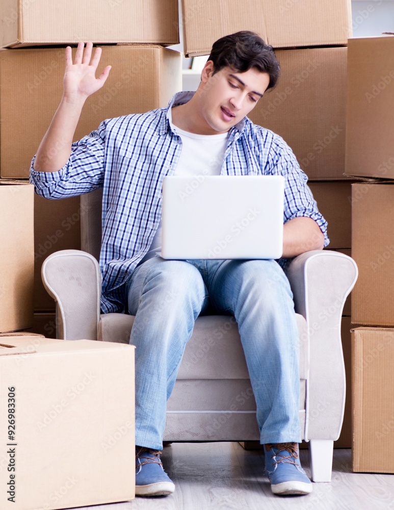 Young man moving in to new house with boxes Young man moving in to new house with boxes