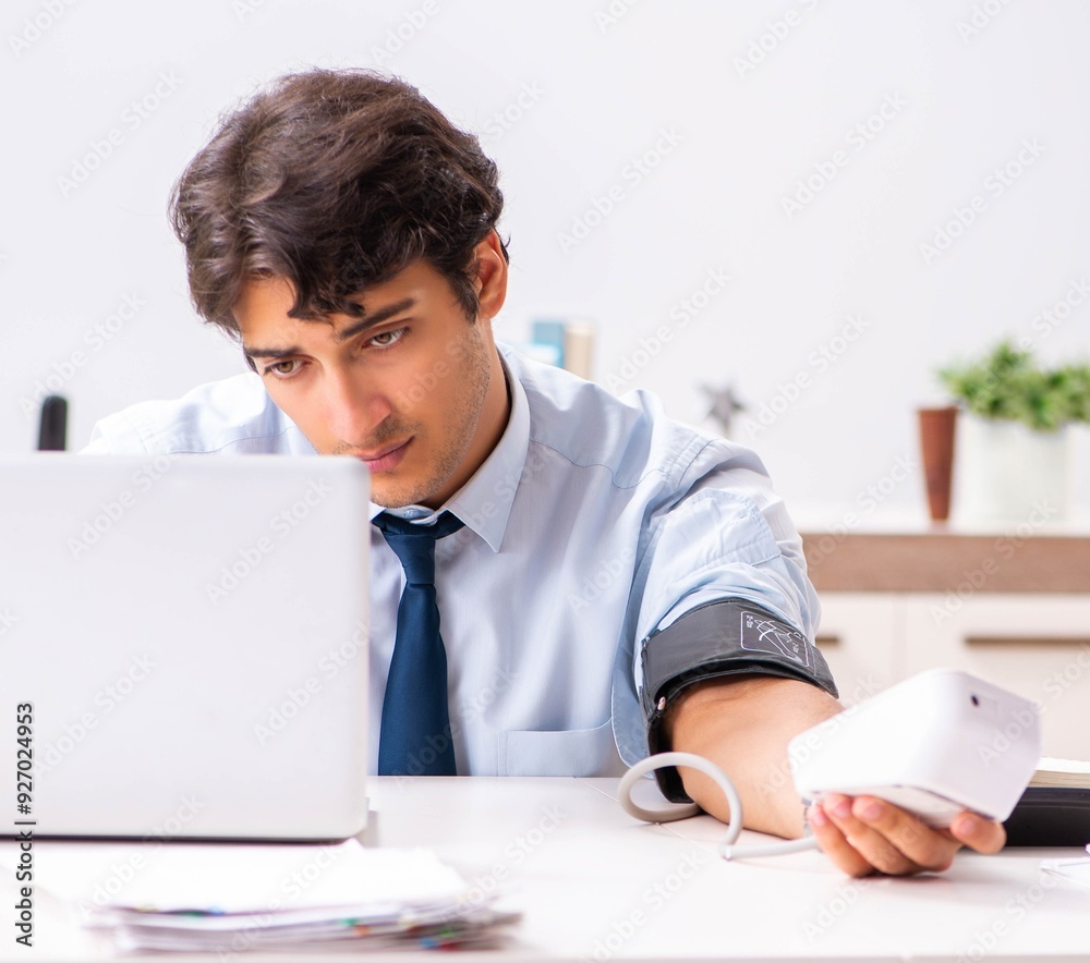 Man under stress measuring his blood pressure Man under stress measuring his blood pressure