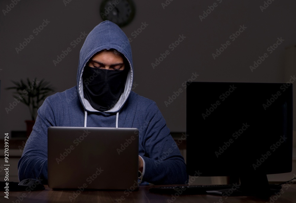 Male hacker hacking security firewall late in office Male hacker hacking security firewall late in office